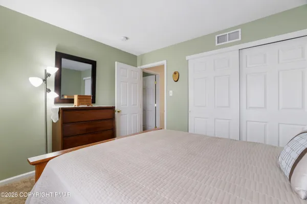 a bedroom with a bed and a mirror