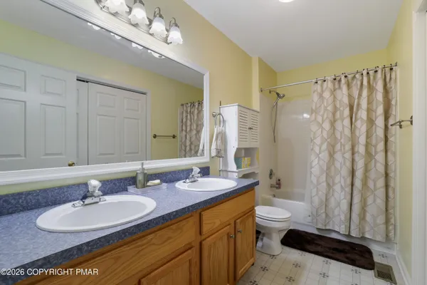 a bathroom with a double vanity sink toilet mirror and shower