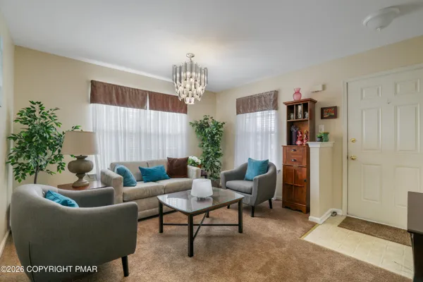 a living room with furniture and a chandelier