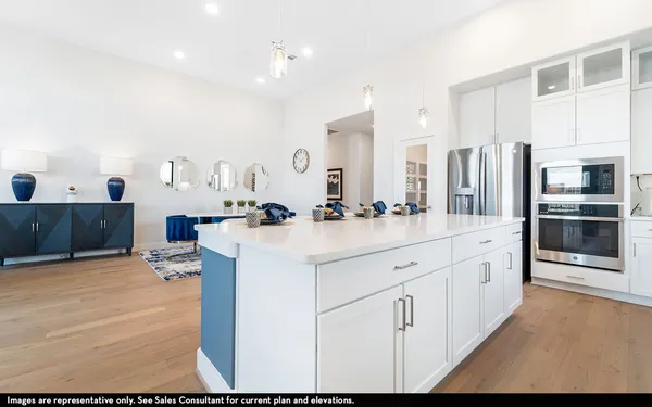 a large white kitchen with stainless steel appliances
