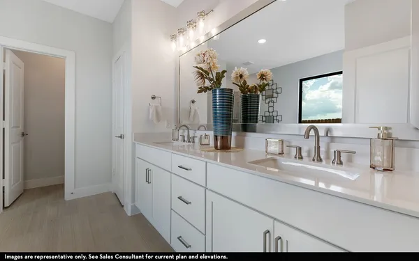 a bathroom with double vanity and a mirror