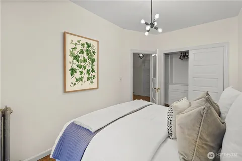 a bedroom with a bed chandelier and a window