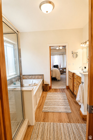 1055 North 1000 East Mapleton, UT 84664 - Photo 13 of 112 Spacious bathroom featuring wood-finish flooring, a soaking tub with tile surround, and a glass-enclosed shower