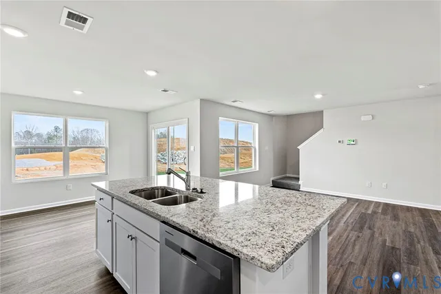 a kitchen with granite countertop a sink and a wooden floor