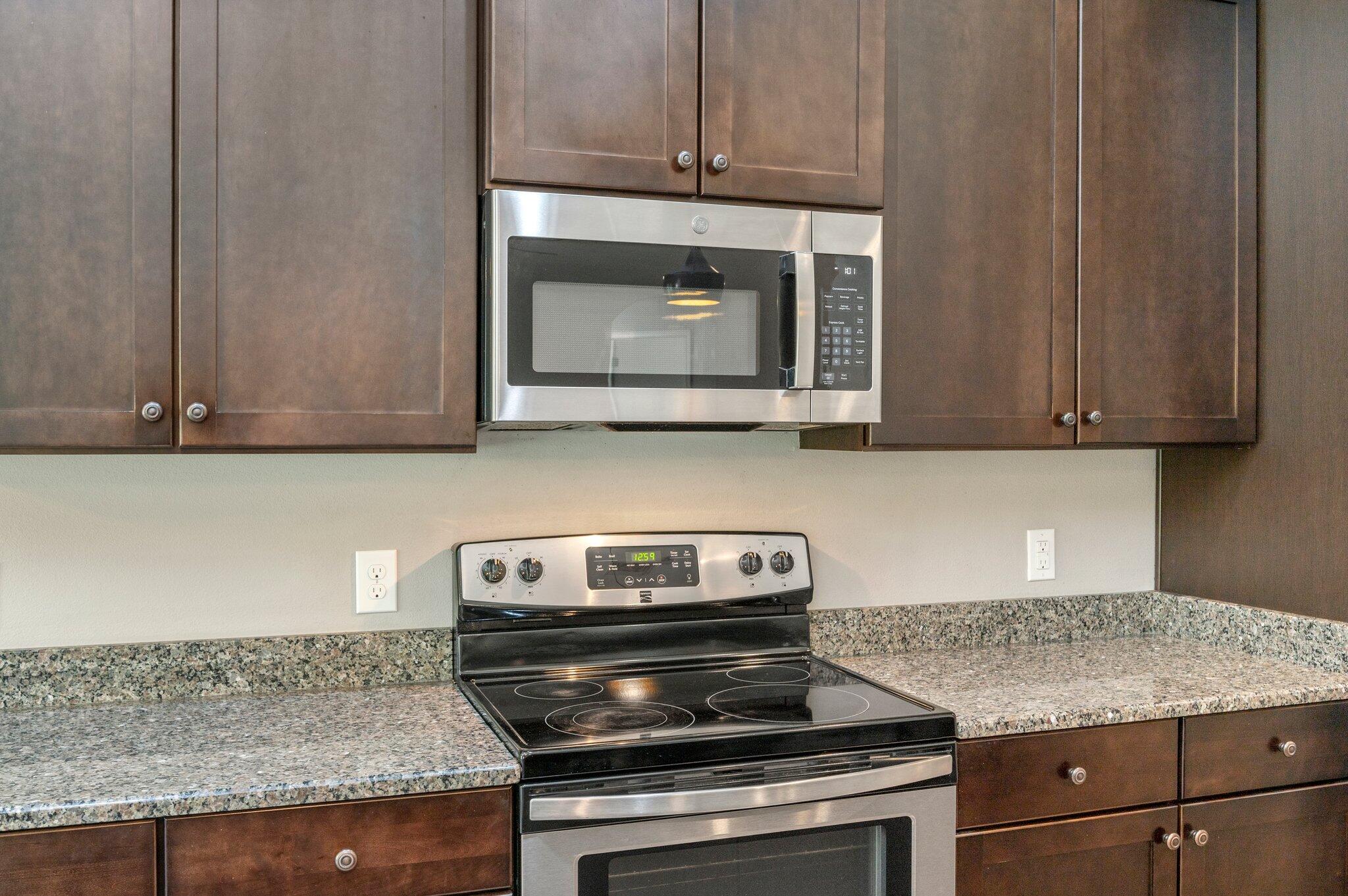 8177 Lucena Street Navarre, FL 32566 - Photo 17 of 51 a kitchen with granite countertop cabinets stove top oven and microwave