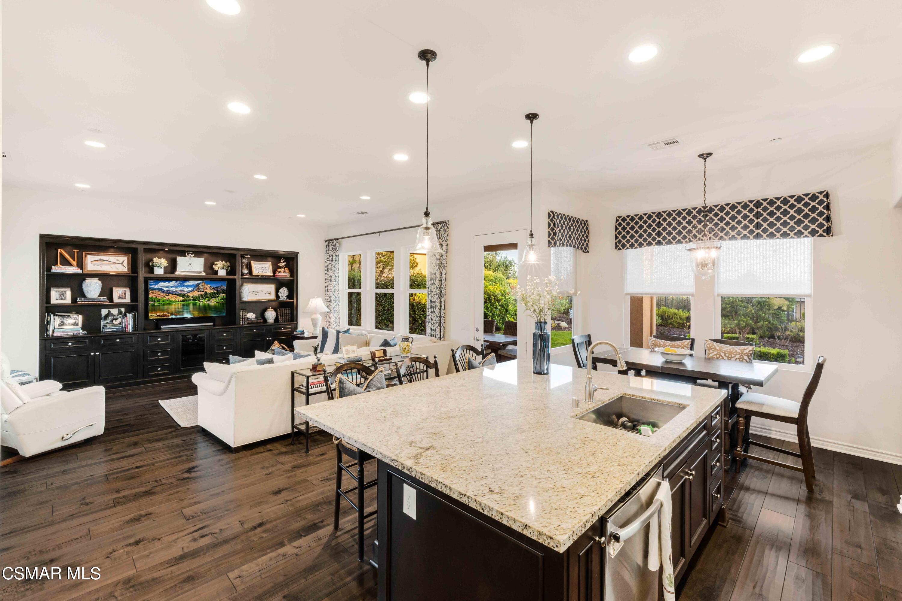 13210 Bent Grass Place Moorpark, CA 93021 - Photo 13 of 73 a view of a dining room and livingroom with furniture wooden floor a rug a fireplace and a chandelier