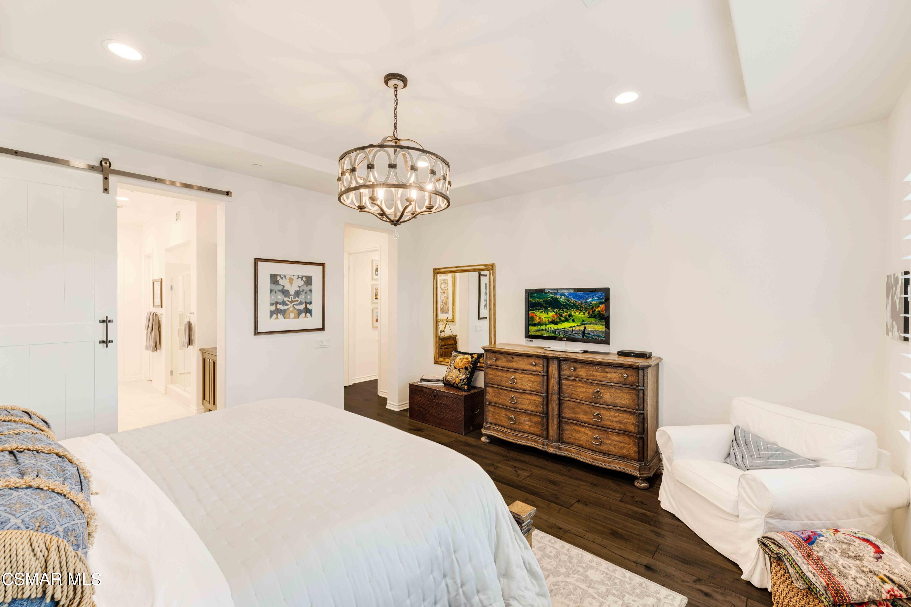 13210 Bent Grass Place Moorpark, CA 93021 - Photo 21 of 73 a spacious bedroom with a bed and a chandelier