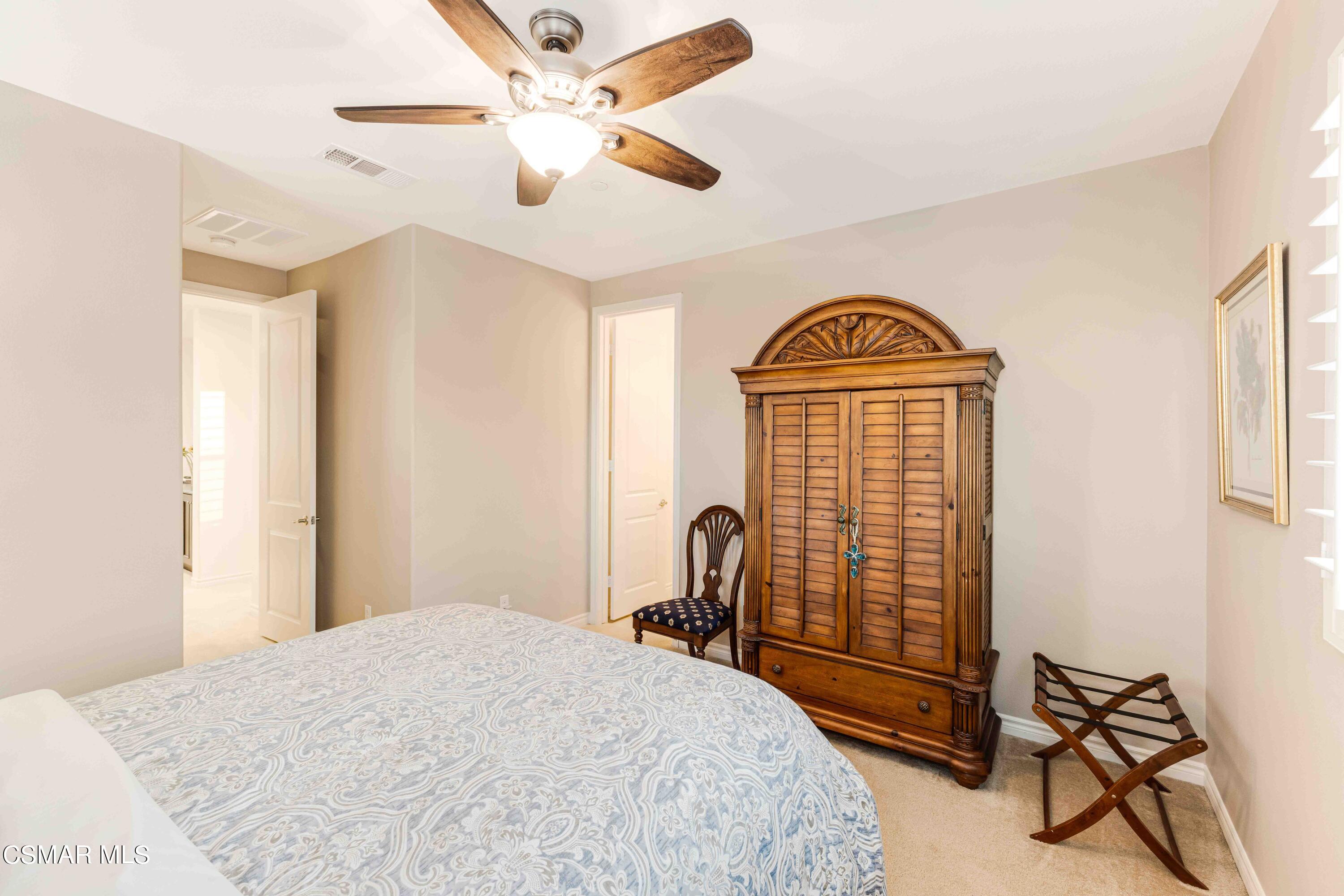 13210 Bent Grass Place Moorpark, CA 93021 - Photo 34 of 73 a bedroom with a bed and a chandelier