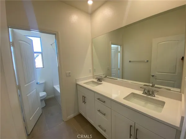 a bathroom with a double vanity sink toilet and a mirror