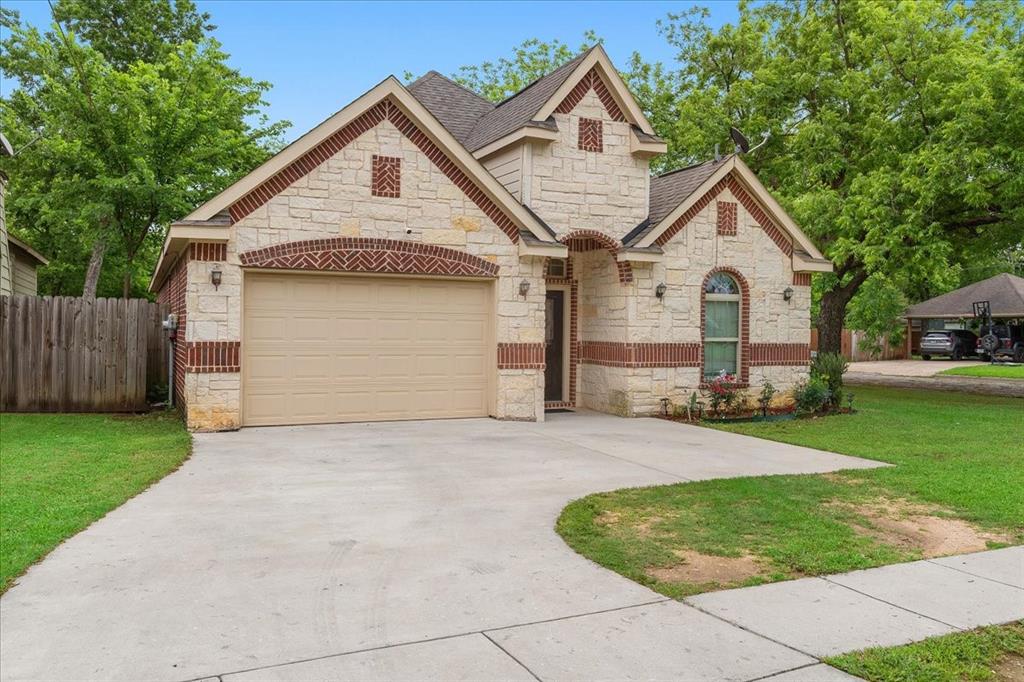 502 Ritchey Street Gainesville, TX 76240 - Photo 2 of 29 a front view of a house with a yard and garage