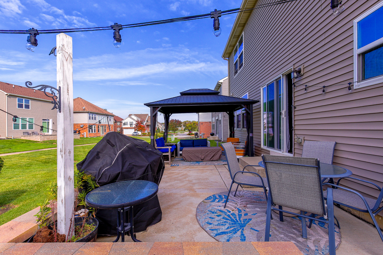 98 Lawrence Lane Matteson, IL 60443 - Photo 20 of 20 a view of a patio with table and chairs under an umbrella with a barbeque