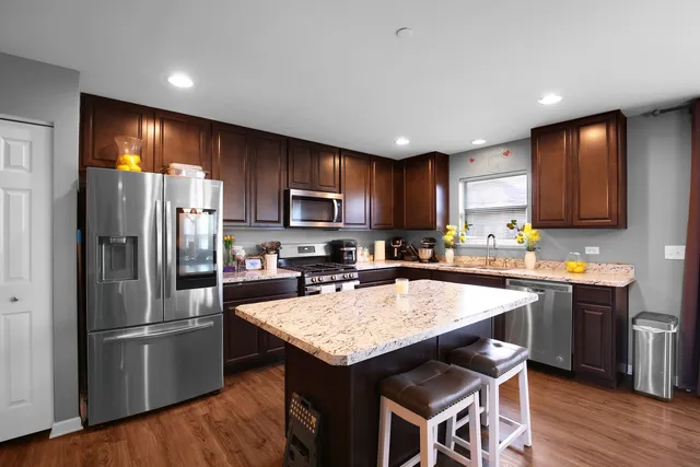 a kitchen with kitchen island a refrigerator stove microwave and cabinets