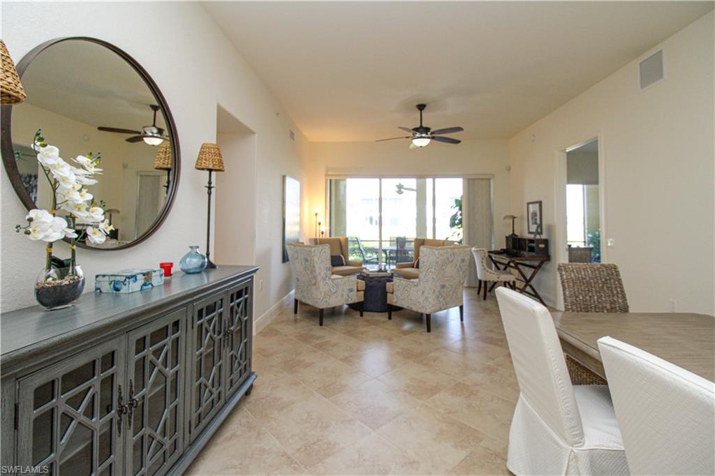 2713 Callista Court, Unit 103 Naples, FL 34114 - Photo 14 of 47 a living room with furniture a mirror and a wooden floor
