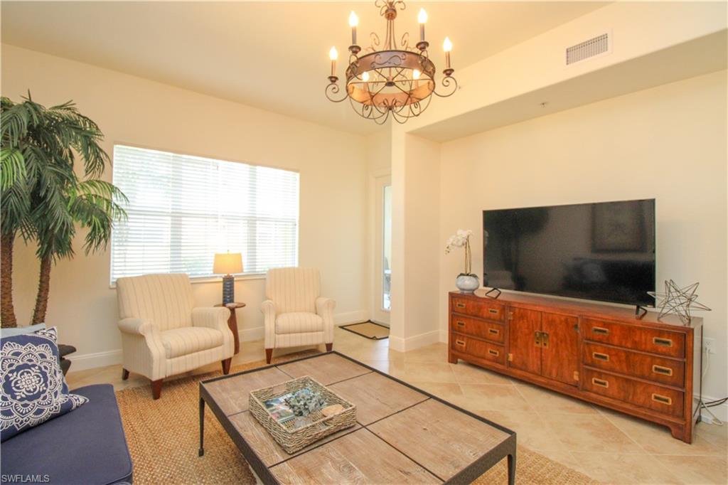 2713 Callista Court, Unit 103 Naples, FL 34114 - Photo 21 of 47 a living room with furniture and a flat screen tv