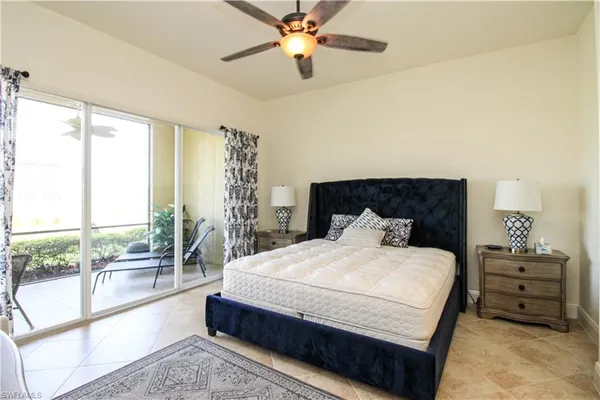 a bedroom with a large bed and a chandelier fan