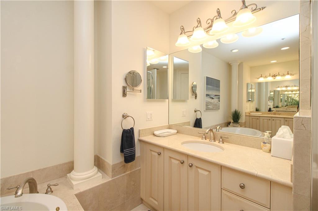 2713 Callista Court, Unit 103 Naples, FL 34114 - Photo 31 of 47 a bathroom with a sink vanity and mirror