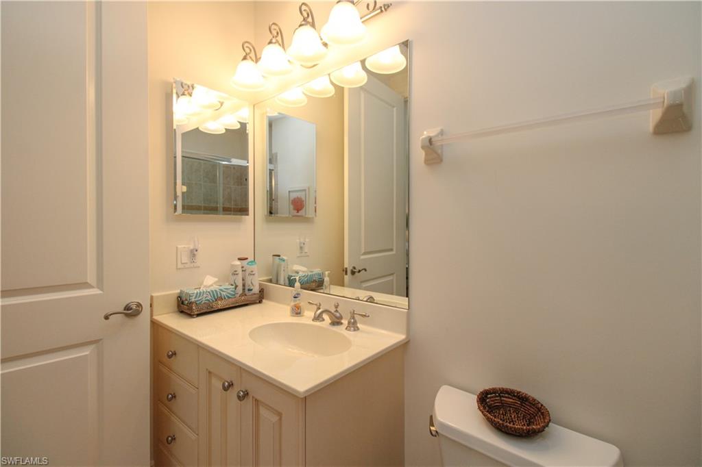 2713 Callista Court, Unit 103 Naples, FL 34114 - Photo 32 of 47 a bathroom with a sink a vanity and a mirror