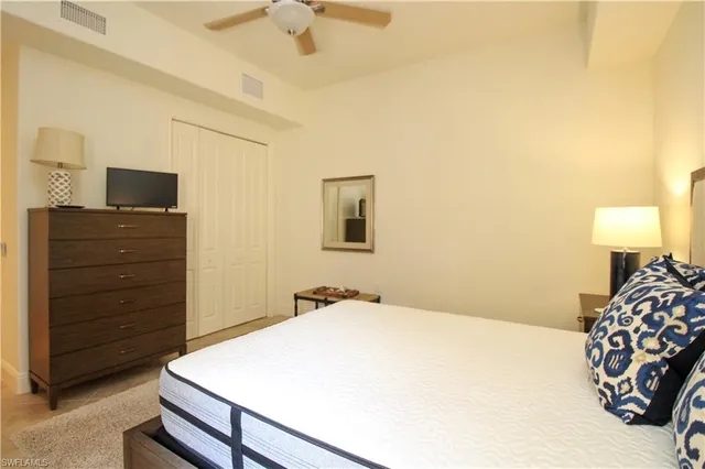 a bedroom with a bed and a tv on a dresser