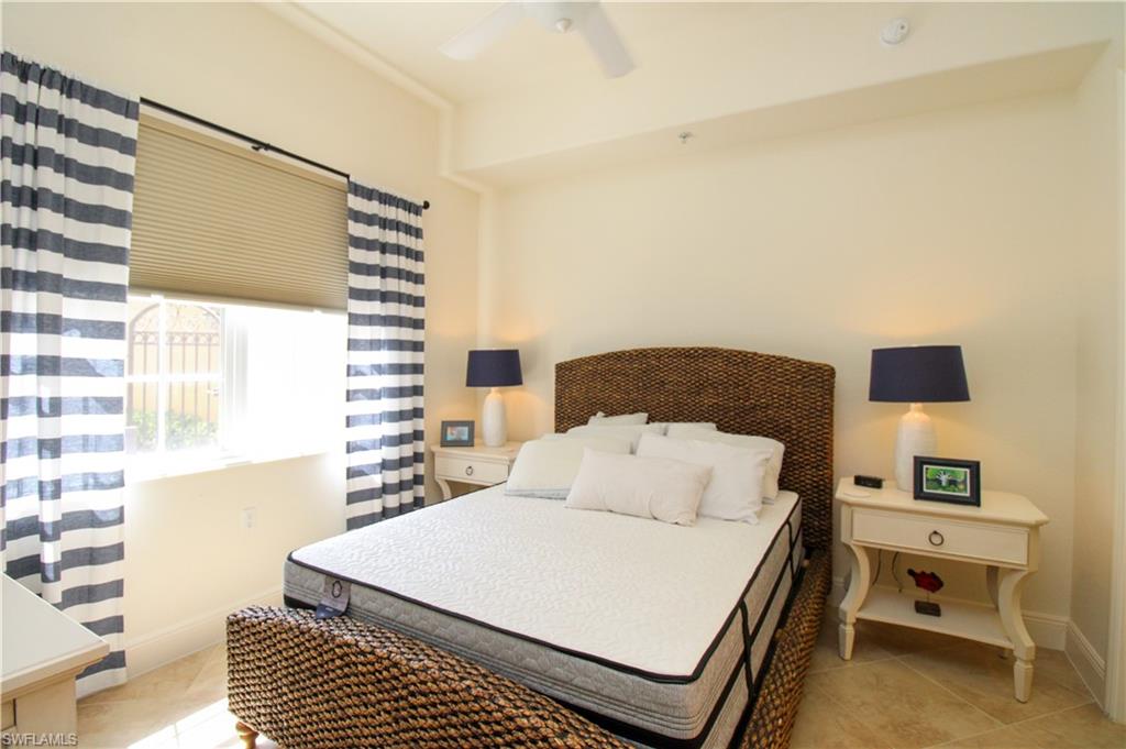 2713 Callista Court, Unit 103 Naples, FL 34114 - Photo 37 of 47 a bedroom with a bed and a night stand