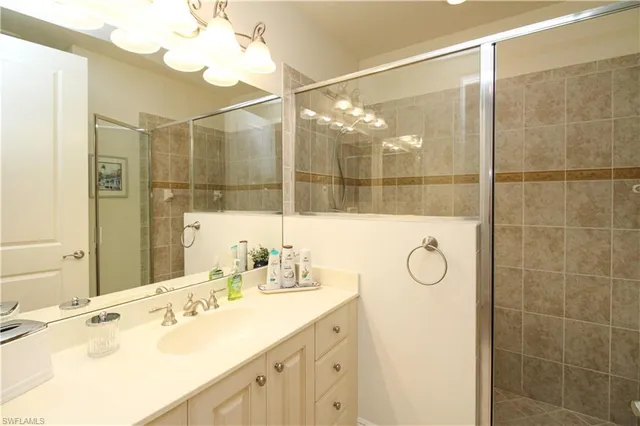 a bathroom with a double vanity sink mirror and shower