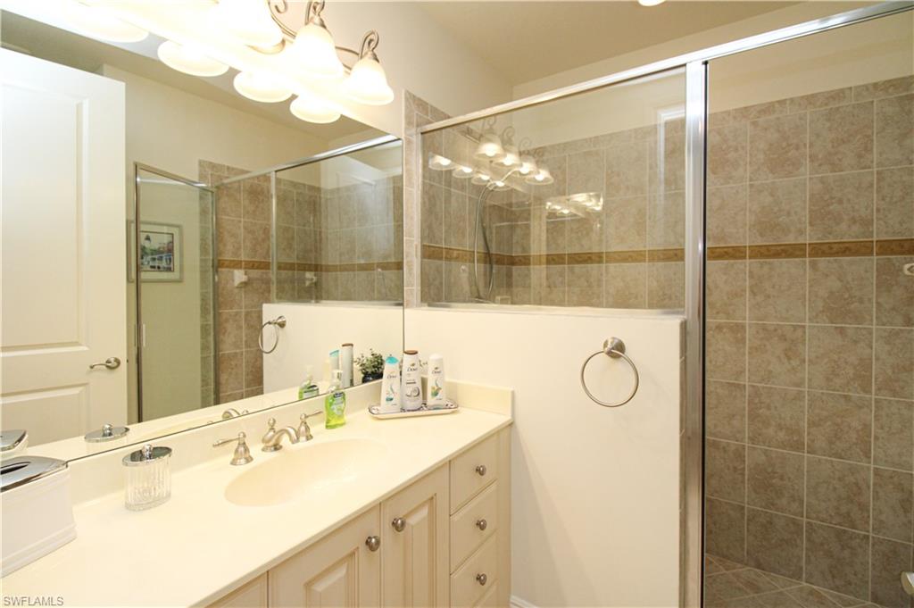 2713 Callista Court, Unit 103 Naples, FL 34114 - Photo 40 of 47 a bathroom with a double vanity sink mirror and shower