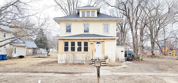 a front view of a house with a yard covered in snow