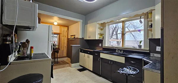 a kitchen with stainless steel appliances a stove a sink and a refrigerator