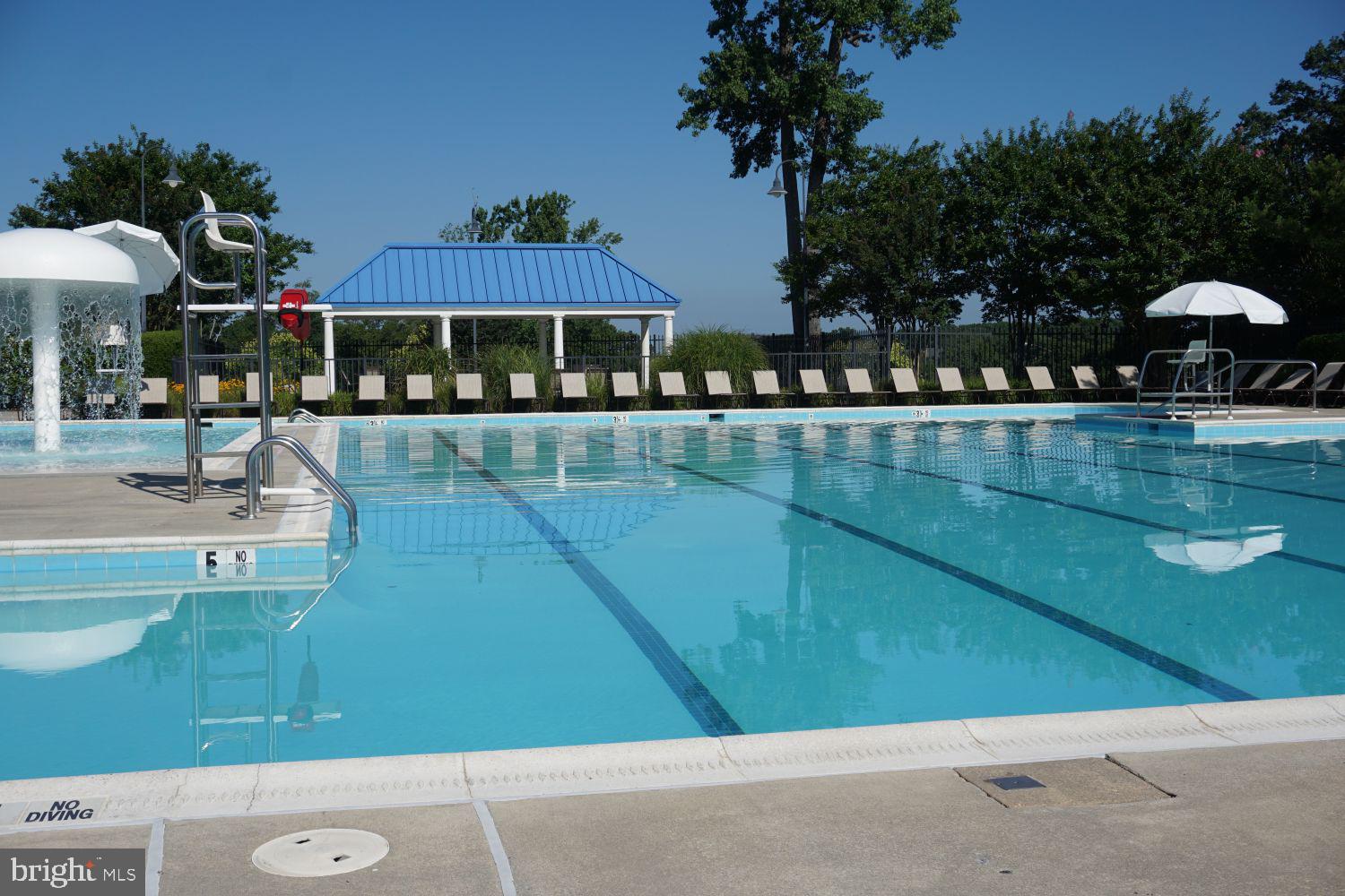 2701 Summers Ridge Drive Odenton, MD 21113 - Photo 46 of 50 a view of a swimming pool with a table and chairs under an umbrella