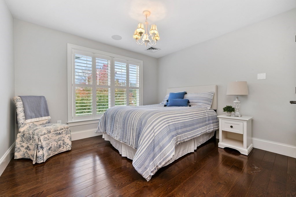 4 Fox Run Way Hingham, MA 02043 - Photo 24 of 34 a spacious bedroom with a bed and a chandelier