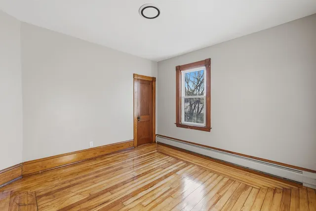 a view of a room with wooden floor and window
