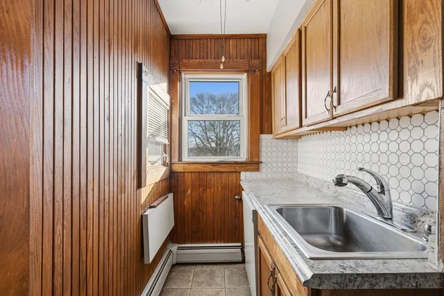 a kitchen with granite countertop white cabinets and sink