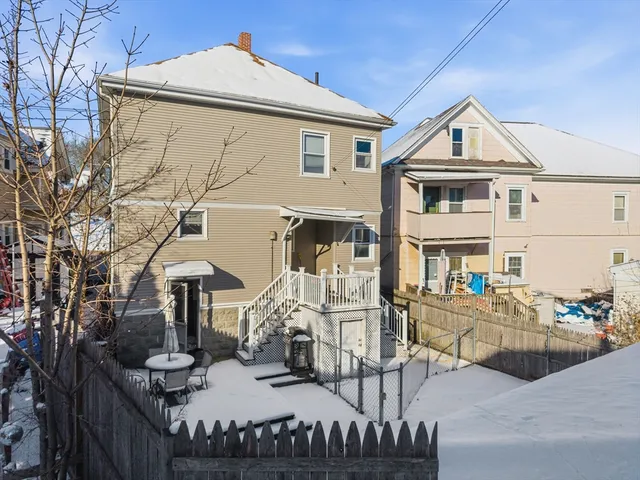 a view of a brick house with couches chairs and floor to ceiling window