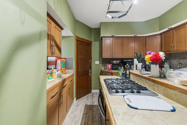 a kitchen with kitchen island granite countertop a stove and a sink