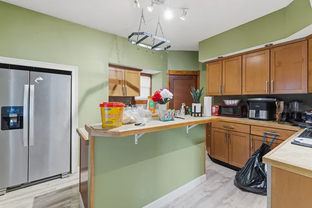 a kitchen with stainless steel appliances granite countertop a refrigerator and a sink