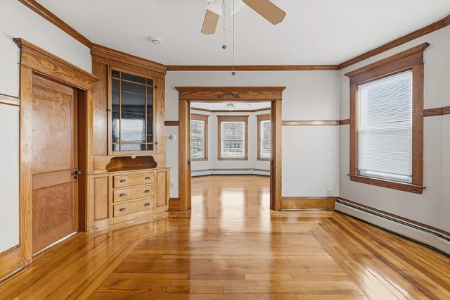 a hallway with hardwood floor and cabinet