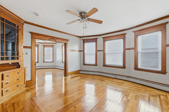 a view of an empty room with window and wooden floor