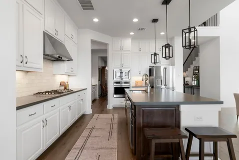 a kitchen with stainless steel appliances granite countertop a sink a stove and a refrigerator