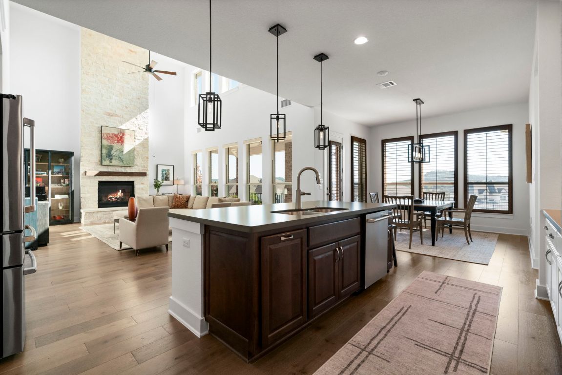 4704 Montorio Way Leander, TX 78641 - Photo 13 of 40 a spacious kitchen with stainless steel appliances granite countertop a sink counter space and living room view