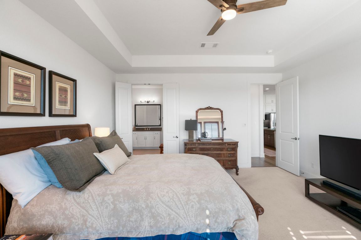 4704 Montorio Way Leander, TX 78641 - Photo 17 of 40 a bedroom with a bed and a flat screen tv