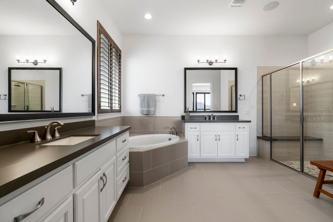 4704 Montorio Way Leander, TX 78641 - Photo 18 of 40 a bathroom with a double vanity sink mirror and bathtub