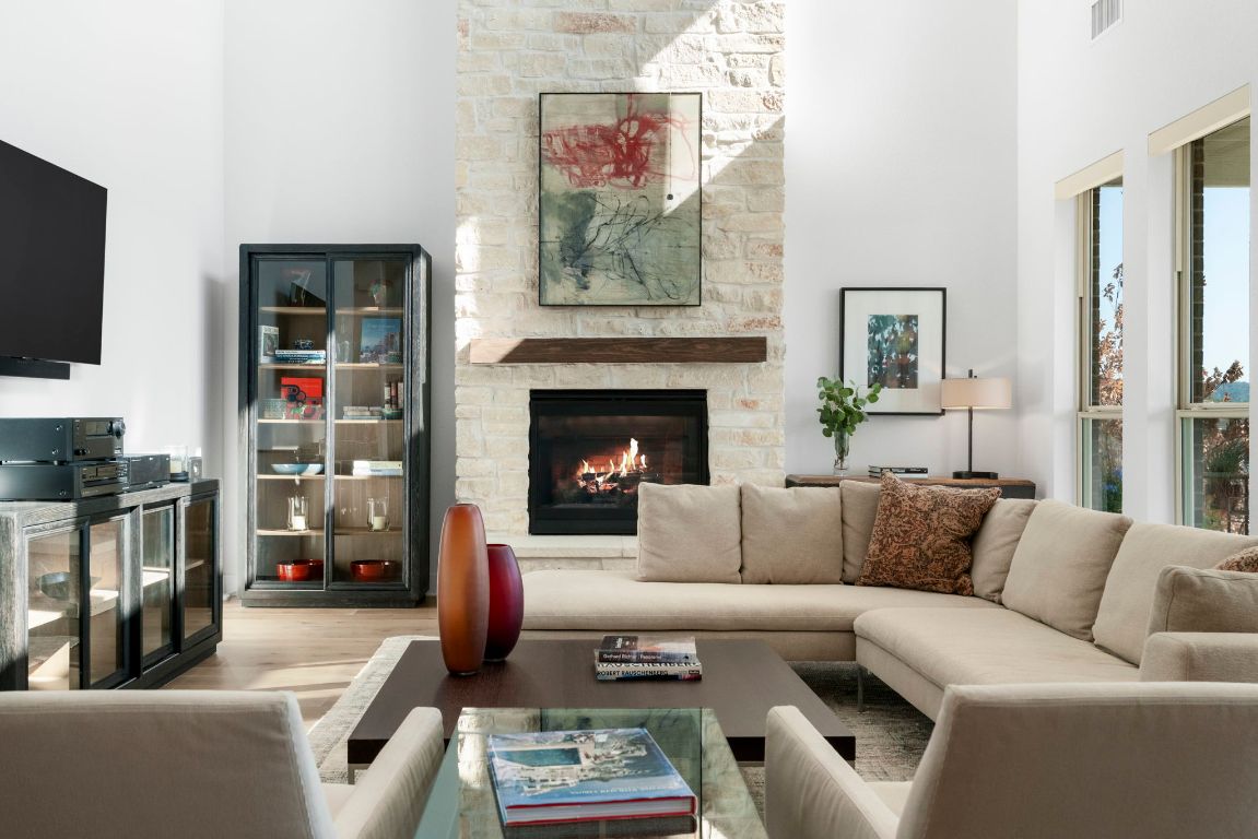 4704 Montorio Way Leander, TX 78641 - Photo 9 of 40 a living room with furniture a flat screen tv and a fireplace