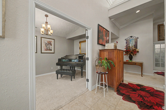 3034 Swiss Drive Santa Clara, UT 84765 - Photo 26 of 59 Entryway featuring a vaulted ceiling and tile flooring, opening to a carpeted room with a multi-arm chandelier