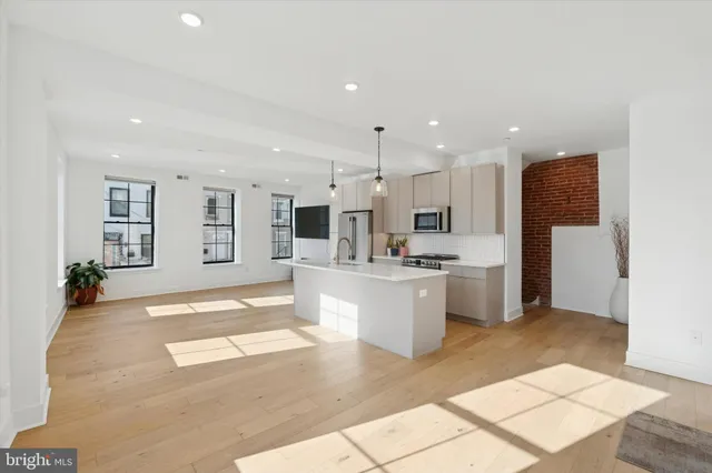 a open kitchen with white cabinets and stainless steel appliances