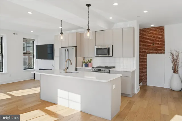 a large kitchen with kitchen island a sink stainless steel appliances and cabinets