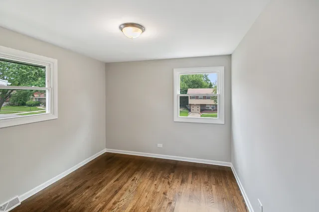 a view of room with window and wooden floor