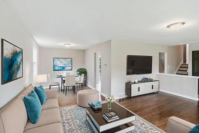 a living room with furniture a flat screen tv and kitchen view