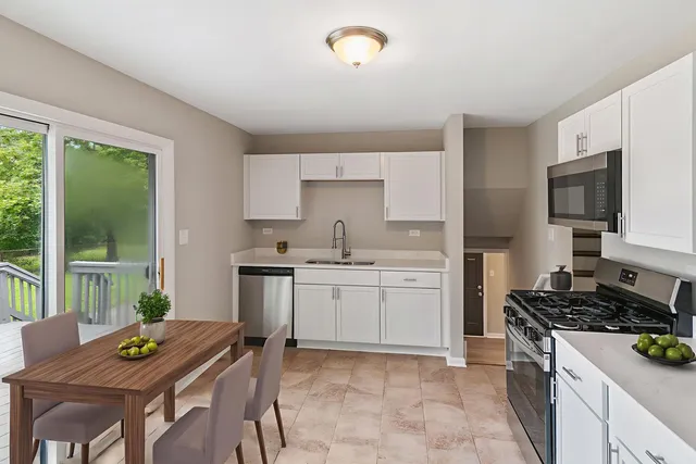 a kitchen that has a sink and chairs in it