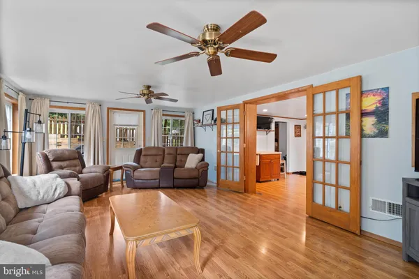 a living room with furniture and a large window with wooden floor