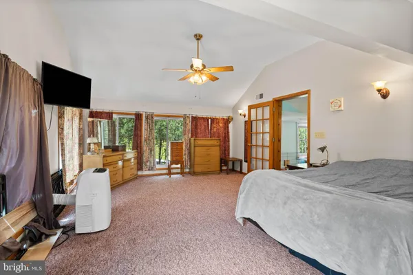 a spacious bedroom with bed and large windows
