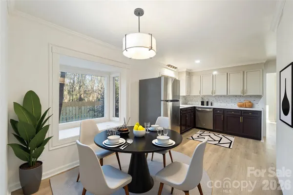 a kitchen with a table chairs stainless steel appliances and cabinets